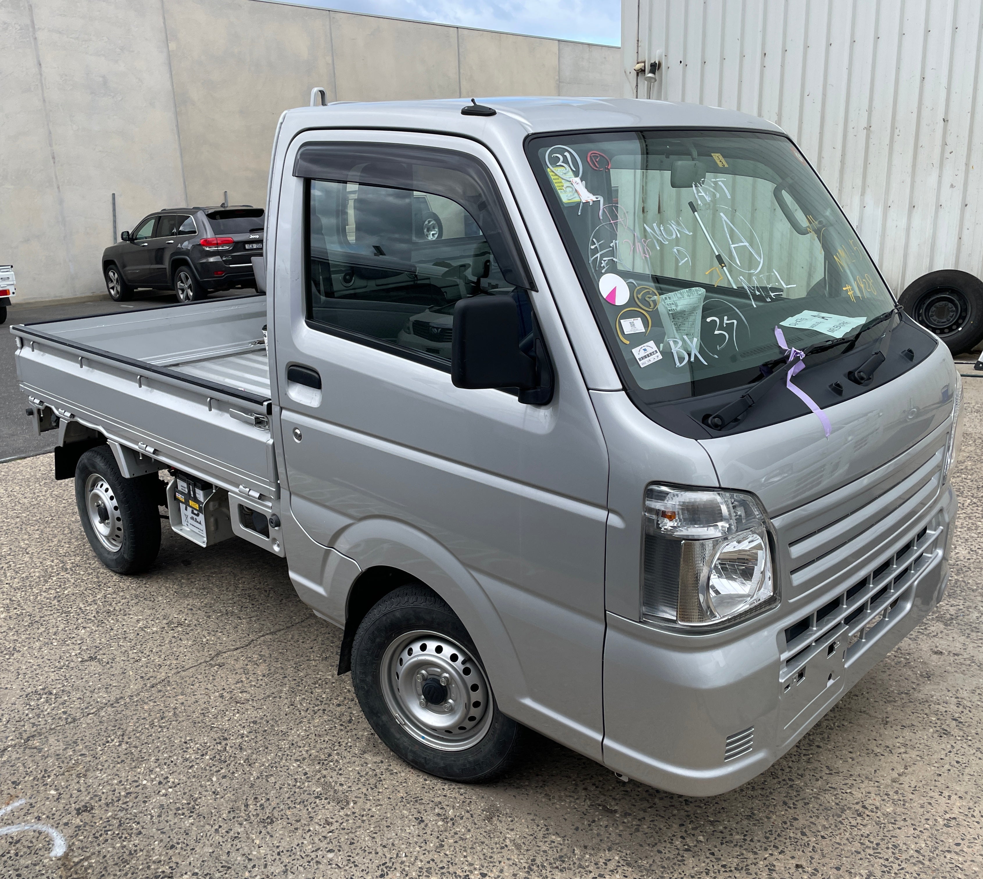A silver Suzuki Carry DA16T at the port in Australia. 
